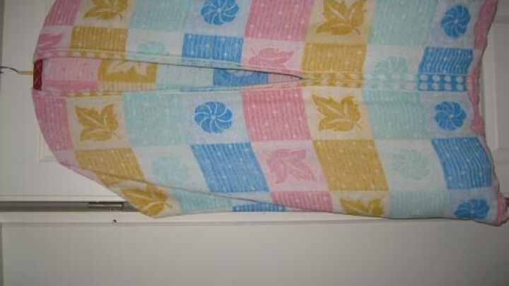 Ein buntes Strandtuch h&auml;ngt an einer T&uuml;r, in der Mitte mit einem Schlitz versehen, um als DIY-W&auml;schesammler zu dienen.