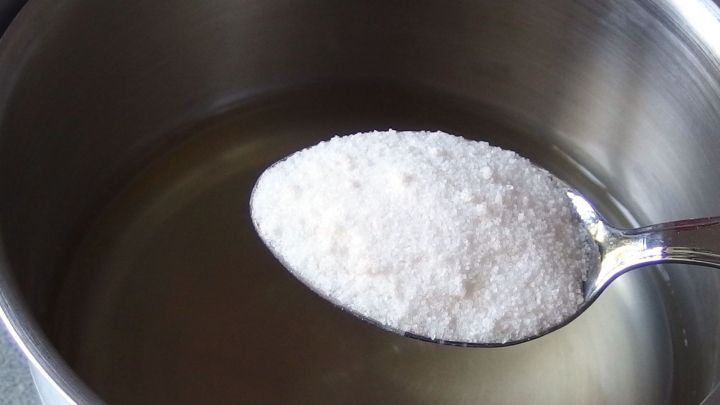 Eine L&ouml;ffel mit wei&szlig;em Pulver liegt &uuml;ber einem Topf mit klarer Fl&uuml;ssigkeit, w&auml;hrend eine Zubereitung f&uuml;r Ersatz-Tortenguss entsteht.