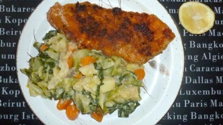 Ein paniertes Schnitzel liegt neben einem bunten Spitzkohleintopf auf einem wei&szlig;en Teller, umgeben von einem Schriftmuster.