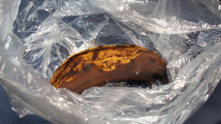 Eine braune, &uuml;berreife Banane liegt in einer durchsichtigen Plastikt&uuml;te, die in einer Wohnung aufbewahrt wird.