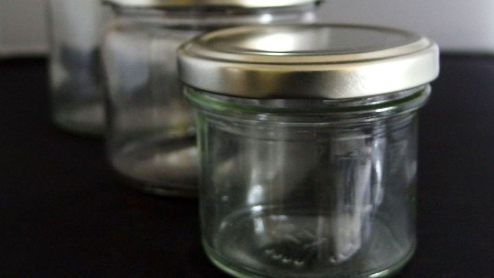 Eingemachte Gl&auml;ser stehen ordentlich auf einer dunklen Oberfl&auml;che, bereit zum Bef&uuml;llen und Konservieren von Lebensmitteln.