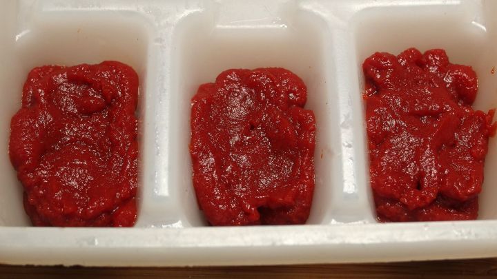 Eisw&uuml;rfel aus Tomatenmark in einer transparenten Form, bereit zur Verwendung in Gerichten oder Getr&auml;nken.