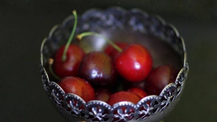 Kirschen liegen in einer eleganten Schale und warten darauf, mit einem Kartoffelsch&auml;ler entkernt zu werden.