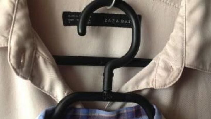 Zwei Kleiderb&uuml;gel h&auml;ngen nebeneinander im Schrank, ein Hemd &uuml;ber einem anderen, platzsparend organisiert.