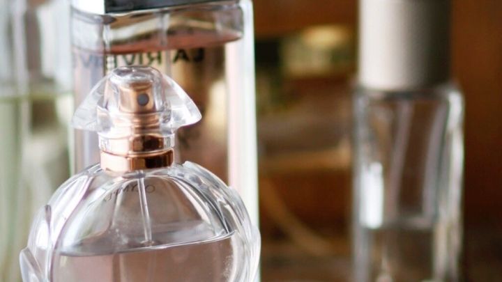 Eine elegante Parf&uuml;mflasche steht auf einem Tisch neben einem Tuch, das Duft und Frische symbolisiert.