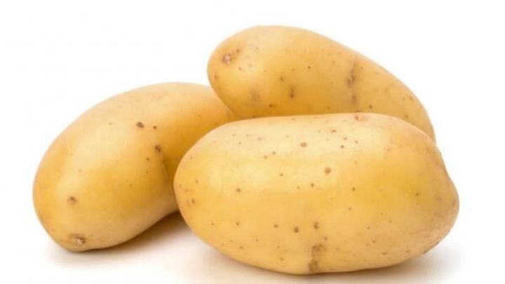 Drei ganze Ofenkartoffeln liegen auf wei&szlig;em Hintergrund, bereit zur Zubereitung in Currysahne.