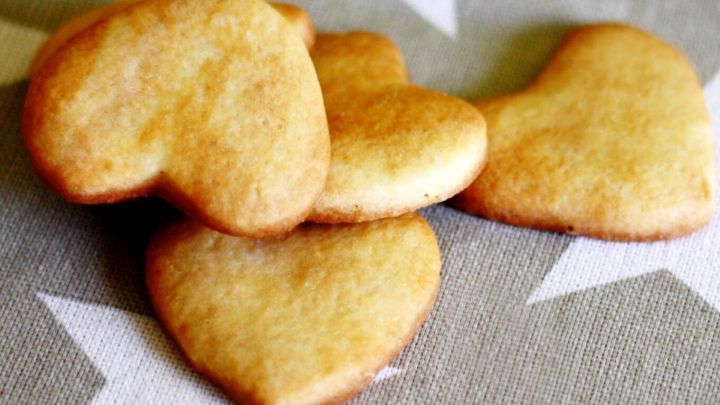 Herzf&ouml;rmige Kekse liegen auf einem grauen Tuch mit wei&szlig;en Sternen, bereit zum Genie&szlig;en &ndash; ideal f&uuml;r salziges und s&uuml;&szlig;es Geb&auml;ck.