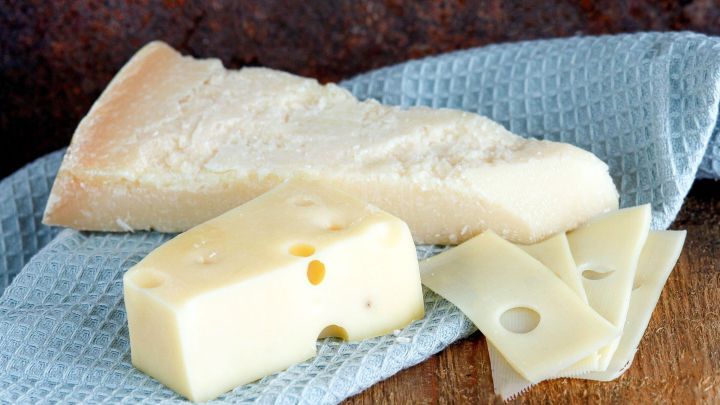 Parmesan und Emmentaler liegen auf einem blauen K&uuml;chentuch, bereit zum &Uuml;berbacken oder f&uuml;r weitere Zubereitungen.