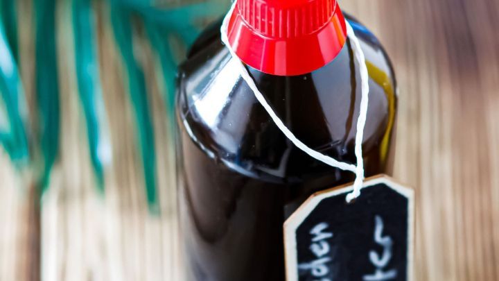 Schwedenbitterflasche steht auf einem Holztisch, w&auml;hrend sie f&uuml;r die Linderung von M&uuml;ckenstichen genutzt wird.