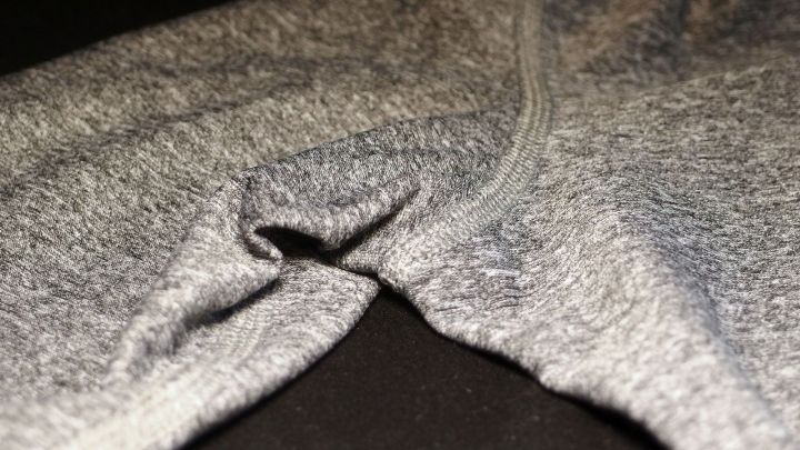 Ein graues Kleidungsst&uuml;ck liegt auf einem dunklen Untergrund und zeigt eine Falte, die auf Schwei&szlig;geruch hinweisen k&ouml;nnte.