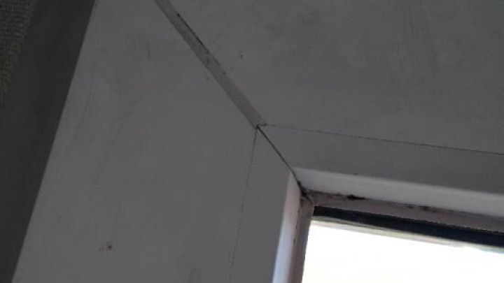 Ein sauberer Fensterrahmen steht offen, w&auml;hrend Tageslicht durch die Scheibe f&auml;llt und den Raum erhellt.