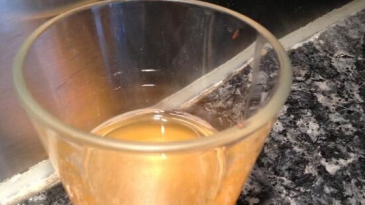 Ein Glas mit Fl&uuml;ssigkeit dient als Fruchtfliegenfalle auf einer K&uuml;chenarbeitsplatte aus Marmor.