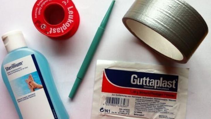 Eine Flasche mit Fl&uuml;ssigkeit und diverse Materialien liegen auf einem Tisch, um Mittel gegen Dornwarzen vorzubereiten.