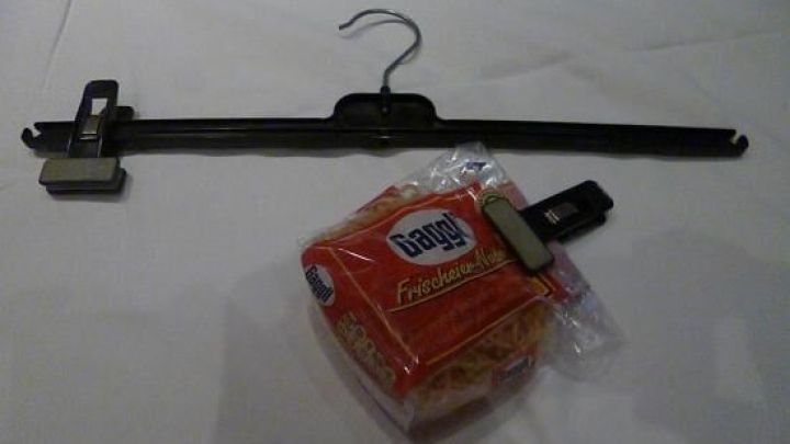 Ein T&uuml;tenverschluss liegt neben einer T&uuml;tenklammer auf einem Tisch, bereit zur Verwendung in der K&uuml;che f&uuml;r frisches Brot.