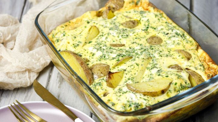 Eine Auflaufform mit goldbraun gebackenen Bratkartoffeln, umgeben von einem rustikalen Tischsetting.