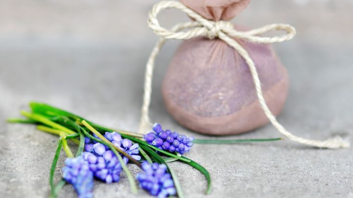 Ein nachhaltig verpackter Beutel liegt neben einem frischen Strau&szlig; lila Blumen, der f&uuml;r ein kreatives Recycling steht.