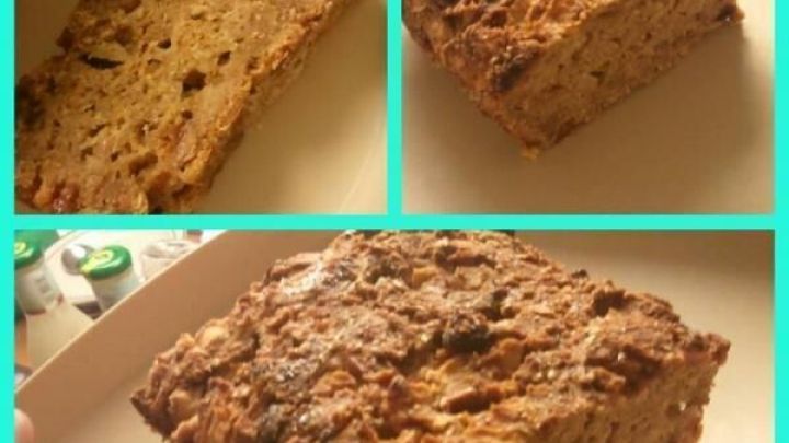 Ein geschnittenes Apfel-Quark-Brot auf einem Teller zeigt seine saftige Textur mit goldbrauner Kruste im K&uuml;chenlicht.