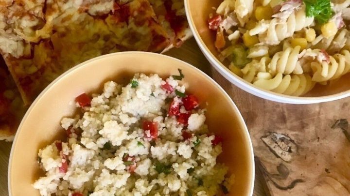 Zwei Schalen mit frischen Nudel- und Couscous-Salaten stehen auf einem Tisch, um Lebensmittelverschwendung zu vermeiden.