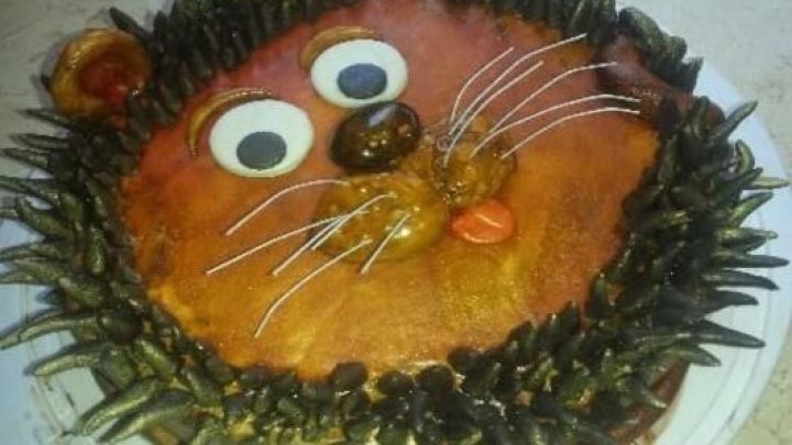 Eine tierf&ouml;rmige Torte in L&ouml;wenform, die mit buntem Fondant und essbaren Dekorationen geschm&uuml;ckt ist.
