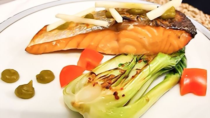 Saftiger Fischfilet liegt auf einem Teller, garniert mit Gem&uuml;se und Saucen, bereit zur schmackhaften Zubereitung.