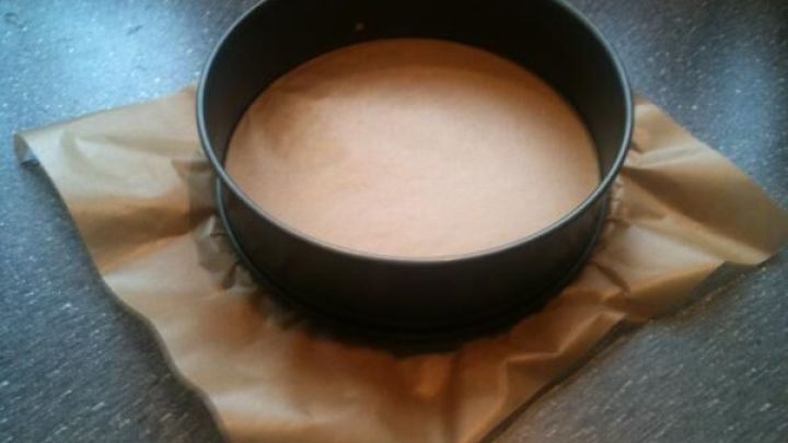 Ein runder Backform steht auf Backpapier, bereit, mit einem Teigdeckel f&uuml;r einen gedeckten Apfelkuchen gef&uuml;llt zu werden.