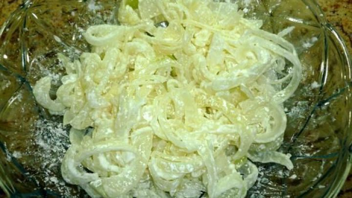 Knusprige Zwiebeln sind in einem Glasbeh&auml;lter serviert, umgeben von einer desodorierten Umgebung, leicht gew&uuml;rzt.