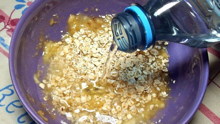 In einer lila Sch&uuml;ssel wird Wasser auf eine Mischung aus Bananen und Haferflocken gegossen, um Bananen-Hafer-Schleim f&uuml;r die Magenberuhigung herzustellen.
