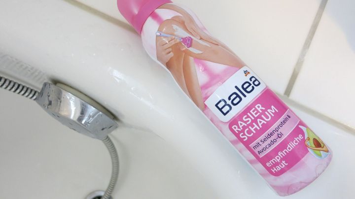 Eine Dose Balea Rasierschaum, beschrieben mit "empfindliche Haut", liegt auf einem Badewannenrand aus Keramik.