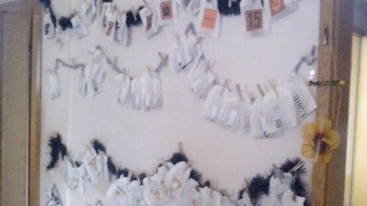 Adventskalender mit Papiert&uuml;ten, die an Seilen mit Klammern h&auml;ngen; verziert mit Zahlen und kleinen Dekorationen.