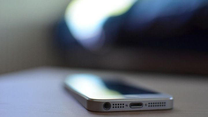 Ein Smartphone liegt auf einem Tisch, w&auml;hrend es m&ouml;glicherweise versucht, nach einem Wasserschaden wieder zu funktionieren.