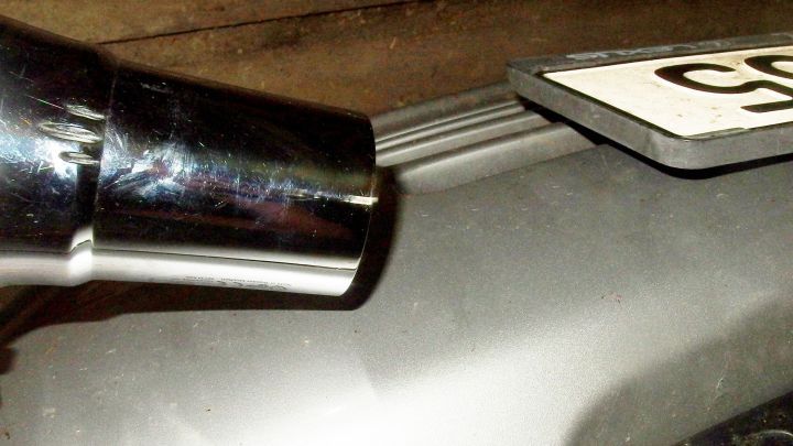 Ein gl&auml;nzendes Auspuffrohr wird an einer Fahrzeugsto&szlig;stange positioniert, um sie aufzufrischen.