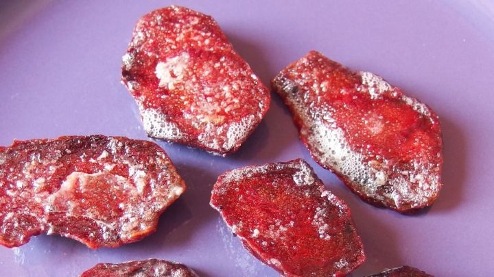 Frittierte Rote Beete liegt appetitlich auf einem lilafarbenen Teller und strahlt eine knusprige Textur aus.