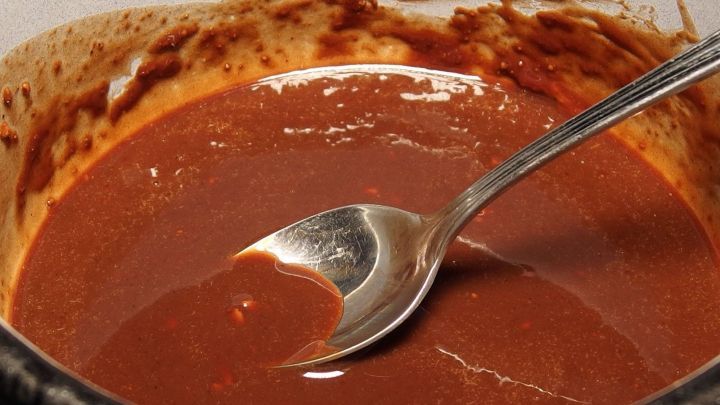 Eine cremige Schoko-Creme wird mit einem L&ouml;ffel in einer Sch&uuml;ssel serviert, umgeben von einem schokoladigen Rand.