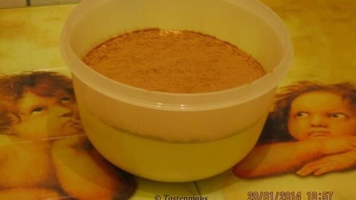 Eine transparente Plastiksch&uuml;ssel mit pulverf&ouml;rmiger Mischung steht auf Tisch mit Engelsmotiven. Text: &copy; Tastenmaus, 20/01/2014 18:57.