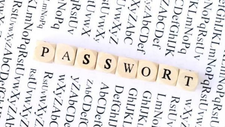 Kleine Holzbuchstaben bilden das Wort "PASSWORT" auf einem hellen Hintergrund mit vielen kleineren Buchstaben.