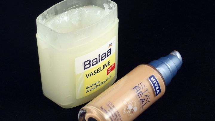 Vaseline und Make-Up in Tuben nebeneinander auf schwarzem Hintergrund, die Vaseline dient als Grundlage f&uuml;r Make-Up.