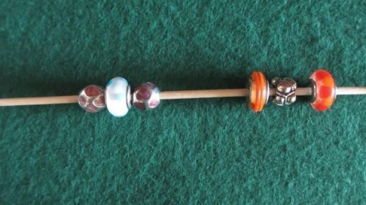 Schmuckelemente sind auf einem Stab angeordnet, um ein kunstvolles Design auf einem gr&uuml;nen Hintergrund zu schaffen.