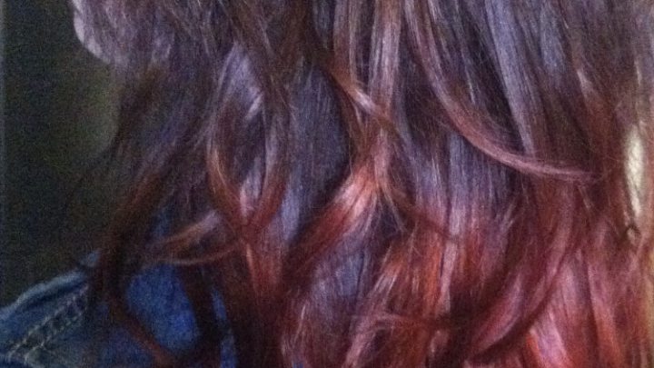 Lange, gewellte Haare in einem r&ouml;tlichen Farbverlauf zeigen Anzeichen von fettigen Haaren durch Spr&uuml;hkur in einer gem&uuml;tlichen Umgebung.