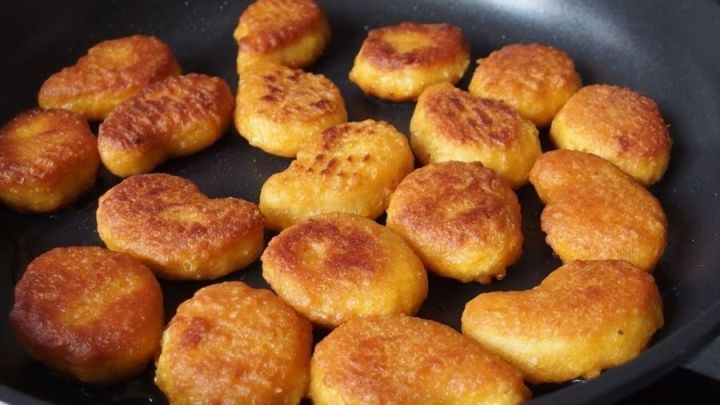 Knusprige Chicken Nuggets liegen goldbraun in einer Pfanne und warten darauf, serviert zu werden.