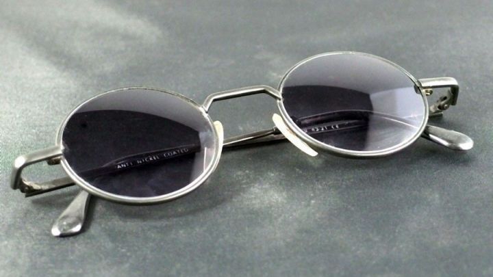 Eine modische Brille liegt auf einem sanften, grauen Untergrund, ideal bei Augen- und Kopfschmerzen w&auml;hrend einer Erk&auml;ltung.