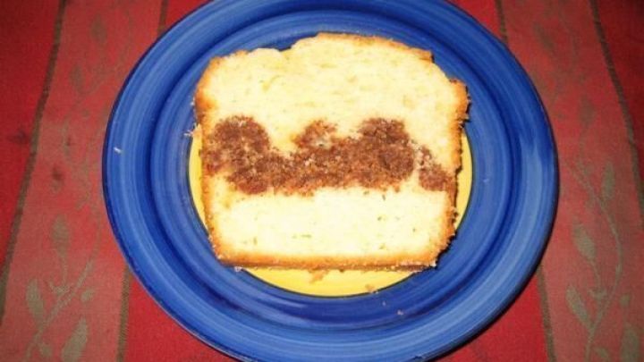 Eine Scheibe Nusskuchen liegt auf einem blauen Teller und zeigt eine ansprechende F&uuml;llung in der Mitte.