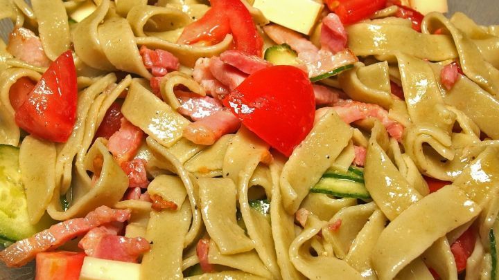 Bunter Nudelsalat mit gr&uuml;nen Pasta- und Gem&uuml;sest&uuml;cken liegt appetitlich in einer Sch&uuml;ssel, bereit zum Servieren.