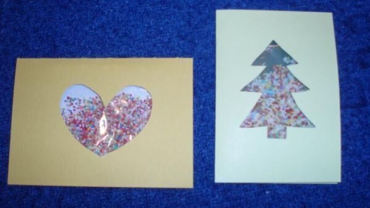 Karten mit buntem Streusel, links Herzform, rechts Tannenbaum, auf blauem Hintergrund. Keine weiteren Texte.