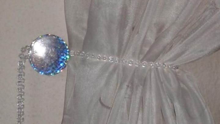 Ein eleganter Gardinen-Raffhalter h&auml;lt einen transparenten Vorhang an einer Wand, ohne Bohren erforderlich zu sein.