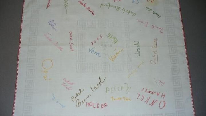 Stofftaschentuch mit gestickten Namen in bunten Farben und der Aufschrift "Meine Konfirmation" auf hellem Hintergrund.