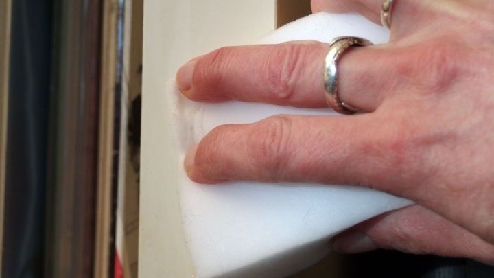 Eine Hand h&auml;lt einen Schmutzradierer und reinigt damit eine vergilbte Oberfl&auml;chenkante im Innenraum.