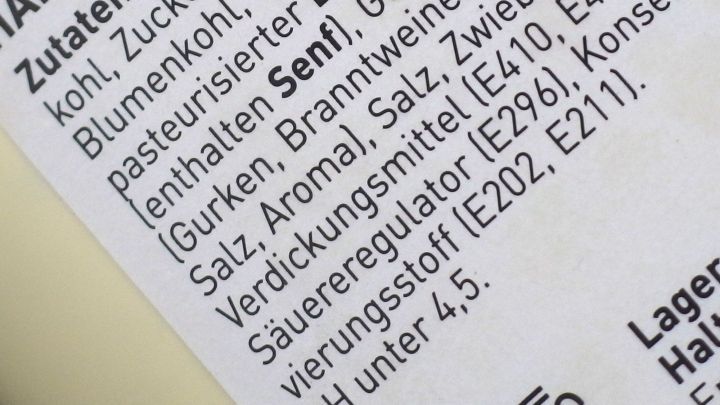 Ein Etikett zeigt Zutaten und Informationen, das Kleingedruckte enth&auml;lt Details zu Senf und Konservierungsstoffen.