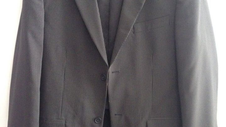 Ein gestreiftes Anzugjackett h&auml;ngt auf einem Holzkleiderb&uuml;gel vor einem wei&szlig;en Hintergrund.