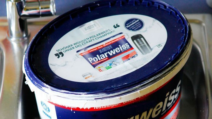 Ein Eimer mit Wandfarbe steht im Waschbecken. Diese Farbe wird nicht ben&ouml;tigt, um die Farbverd&uuml;nnung zu erreichen.