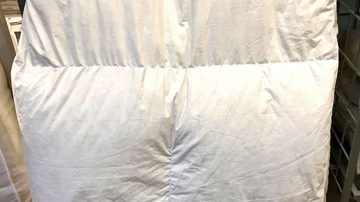 Ein Federbett wird in einer Waschmaschine gewaschen, um es sauber und frisch zu halten. Die Umgebung ist eine Waschk&uuml;che.